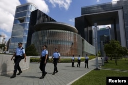 FILE - Policemen patrol at the park in front of Legislative Council (C) and government headquarters (R) in Hong Kong, China.