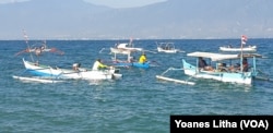 Para nelayan yang berada diatas perahu meraka dalam kegiatan upacara bendera memperingati HUT ke-74 RI di Kelurahan Mamboro, Palu Utara, Kota Palu, Sulawesi Tengah, Sabtu, 17 Agustus 2019. (Foto: Yoanes Litha/VOA)