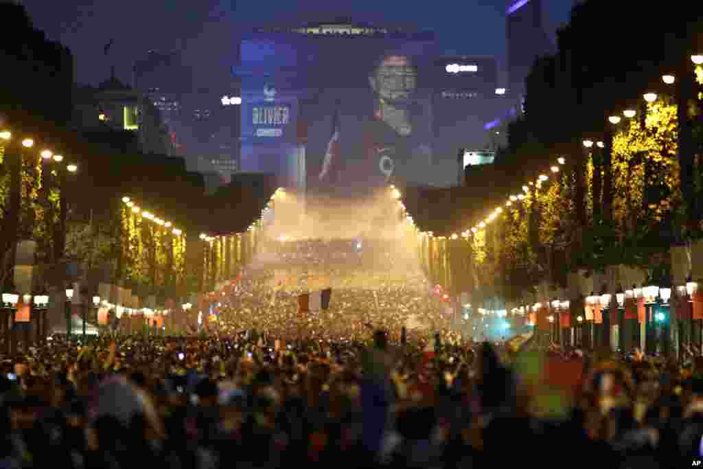 The name of French soccer striker Olivier Giroud is projected onto the Arc de Triomphe as soccer fans invade the Champs Elysees avenue in Paris after France won the soccer World Cup final match between France and Croatia, July 15, 2018. France won its second World Cup title by beating Croatia 4-2 .