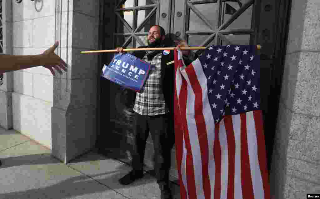Kern Carlos Huerta, um apoiante de Donald Trump coloca-se à frente do capitólio do Estado do Utah em Salt Lake City, enquanto manifestantes protestam contra a eleição do republicano Donald Trump como Presidente dos EUA. Nov. 12, 2016.
