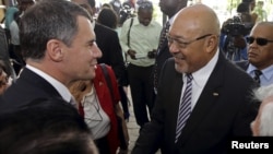 Suriname's President Desi Bouterse (R) is congratulated by Brazil's ambassador to Suriname, Marcelo Baumbach, after he was re-elected to office by the National Assembly in Paramaribo, July 14, 2015. 