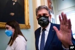 FILE - Sen. Joe Manchin, D-W.Va., walks past reporters at the Capitol in Washington, Dec. 16, 2021.