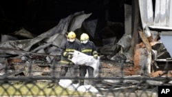 Firefighters prepare bags that appear to contain the remains of victims from a poultry processing plant that was engulfed by a fire in northeast China's Jilin province's Mishazi township, June 3, 2013.