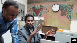 FILE - Mohamed Farah (left) executive director of Ka Joog, talks with Vice President Daud Mohamed in Minneapolis, Feb. 27, 2014. Ka Joog is a Somali nonprofit organization in Minneapolis that has turned down money from the Trump administration.