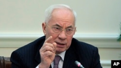 FILE - Ukrainian Prime Minister Mykola Azarov gestures while speaking during a cabinet meeting in Kiev, Ukraine, Wednesday, Dec. 18, 2013.