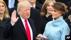 도널드 트럼프 미국 대통령이 지난해 1월 20일 연방의사당에서 열린 취임식에서 부인 멜라니아 여사가 지켜보는 가운데 취임선서를 하고 있다.