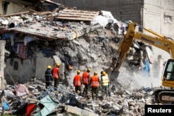 Emergency personnel work at the scene after a building collapsed in a residential area of Nairobi, Kenya, June 13, 2017.