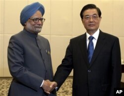 Le Premier ministre indien Manmohan Singh (à gauche) salué par le président chinois Hu Jintao à Sanya