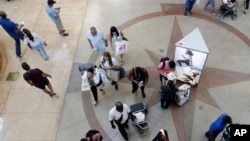 FILE- In this Nov. 23, 2018, file photo shoppers walk through Dolphin Mall in Miami. (AP Photo/Lynne Sladky, File)