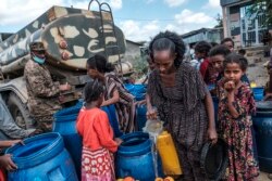 Warga mengambil air yang didistribusikan oleh Pasukan Pertahanan Ethiopia di desa Hadaelga, sebelah barat kota Alamata, 10 Desember 2020. (Foto oleh EDUARDO SOTERAS / AFP)