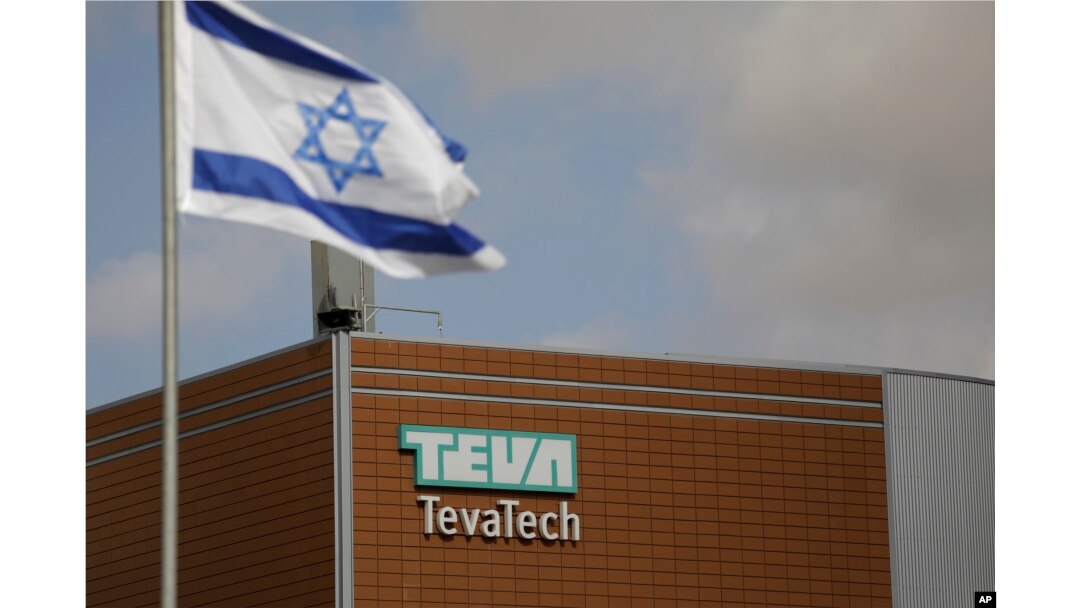 FILE - An Israeli flag flies outside a Teva Pharmaceutical Industries building, in Neot Hovav, Israel, Dec. 14, 2017.