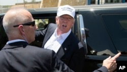 Presidential candidate Donald Trump talks to protesters as he leaves the World Trade Bridge border crossing in Laredo, Texas, July 23, 2015.