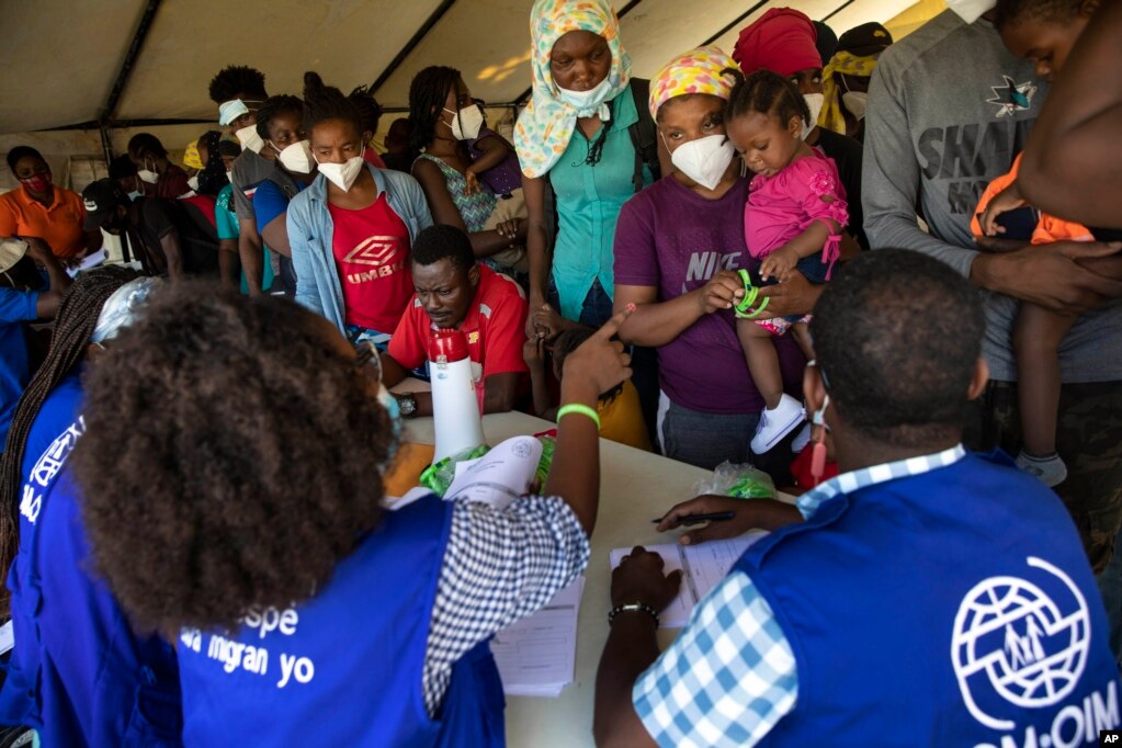 在太子港机场，联合国移民组织的人员接待被美国遣送回国的海地人，准备让他们接受新冠病毒测试。(2021年9月20日)(photo:VOA)