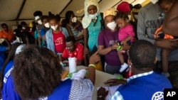 Migran Haiti yang dideportasi dari Texas dan baru tiba di bandara Toussaint Louverture di Port-au-Prince ditemui oleh petugas organisasi migran PBB (IOM) (foto: dok).