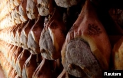 FILE - Lines of Parma hams are hung to dry in a special room in Langhirano near Parma, Italy, Oct. 13, 2009.