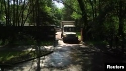 A still image taken from a video footage shows trucks packed with furniture and diplomats' belongings leaving a dacha compound used by U.S. diplomats for recreation, in Serebryany Bor residential area in the west of Moscow, Russia, Aug. 1, 2017.
