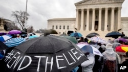 Para pendukung hak-hak untuk melakukan aborsi memegang payung dengan tulisan “#AkhiriKebohongan” dalam sebuah pawai akbar di luar Mahkamah Agung di Washington, D.C. tanggal 20 Maret 2018 saat pengadilan mendengarkan argumen terkait hak-hak untuk kebebasan berbicara menyangkut upaya pemerintah negara bagian California untuk mengatur pusat-pusat krisis kehamilan yang menentang aborsi (foto: AP Photo/Andrew Harnik)