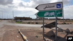 A road sign pointing to the town of Tawergha, a former bastion of support for Moammar Gadhafi, has been painted over with "Misrata," in Arabic, as part of score-settling following Libya's eight-month civil war. 