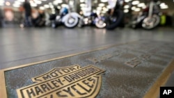 FILE - Rows of motorcycles are seen behind a bronze plate with corporate information on the showroom floor at a Harley-Davidson dealership in Glenshaw, Pennsylvania, April 26, 2017.