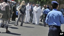 Yemeni security forces and forensics personnel attend the scene where an attack took place on a convoy carrying a senior British diplomat in San'a, Yemen, 06 Oct 2010