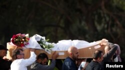 People carry the body of a victim during a burial ceremony for those killed in the mosque attacks, at the Memorial Park Cemetery in Christchurch, New Zealand, March 22, 2019.