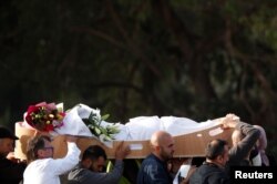 People carry the body of a victim during a burial ceremony for those killed in the mosque attacks, at the Memorial Park Cemetery in Christchurch, New Zealand, March 22, 2019.