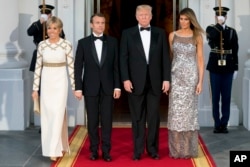 President Donald Trump, first lady Melania Trump, French President Emmanuel Macron and his wife Brigitte Macron, pose for photographs as they arrive for a State Dinner at the White House in Washington, April 24, 2018.