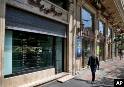 Currency exchange shops line a street in downtown Tehran, Iran, Aug. 7, 2018. Money exchange shops across Iran cautiously reopened on Tuesday after being shut for five months.