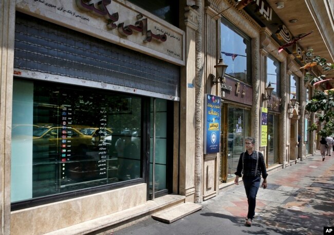 Currency exchange shops line a street in downtown Tehran, Iran, Aug. 7, 2018. Money exchange shops across Iran cautiously reopened on Tuesday after being shut for five months.