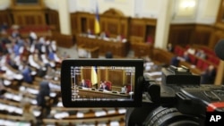 FILE - The rostrum of Ukraine's parliament is seen through a reporter's camera monitor in Kyiv, Sept. 17, 2015.