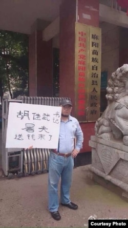 吴淦在麻阳县政府门外举牌。(照片来源：新浪微博)