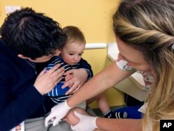 BACKGROUND - August Goepferd, 15 months old, received a booster injection for measles, mumps and rubella in a clinic at the Children's Minnesota in Minneapolis.