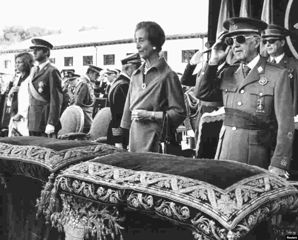 Mantan diktator Spanyol Jenderal Francisco Franco memberikan hormat di samping istrinya Carmen Polo, Juan Carlos ketika masih menjadi Pangeran Spanyol dan istrinya Putri Sofia sambil mendengarkan lagu kebangsaan nasional dalam sebuah upacara di Istana El Pardo, 4 Oktober 1975.