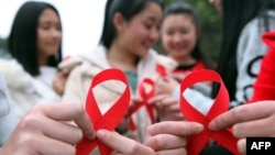 FILE - Volunteers take part in an event to mark World AIDS Day in Chongqing, China, Nov. 30, 2015. 