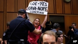 Una mujer protesta contra el candidato a la Corte Suprema, Brett Kavanaugh durante la audiencia de confirmación del Comité Judicial del Senado. 