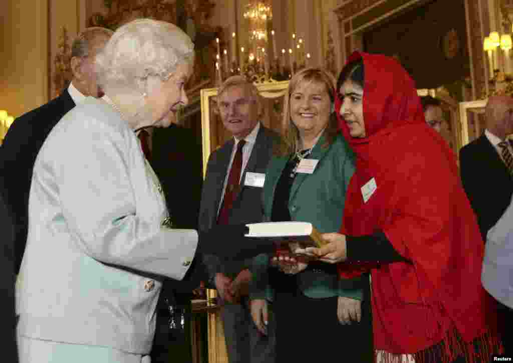 Pokistonlik o'quvchi qiz Malala Yusufzoy o'z kitobini Britaniya qirolichasi Elizabeta II ga topshirmoqda, London