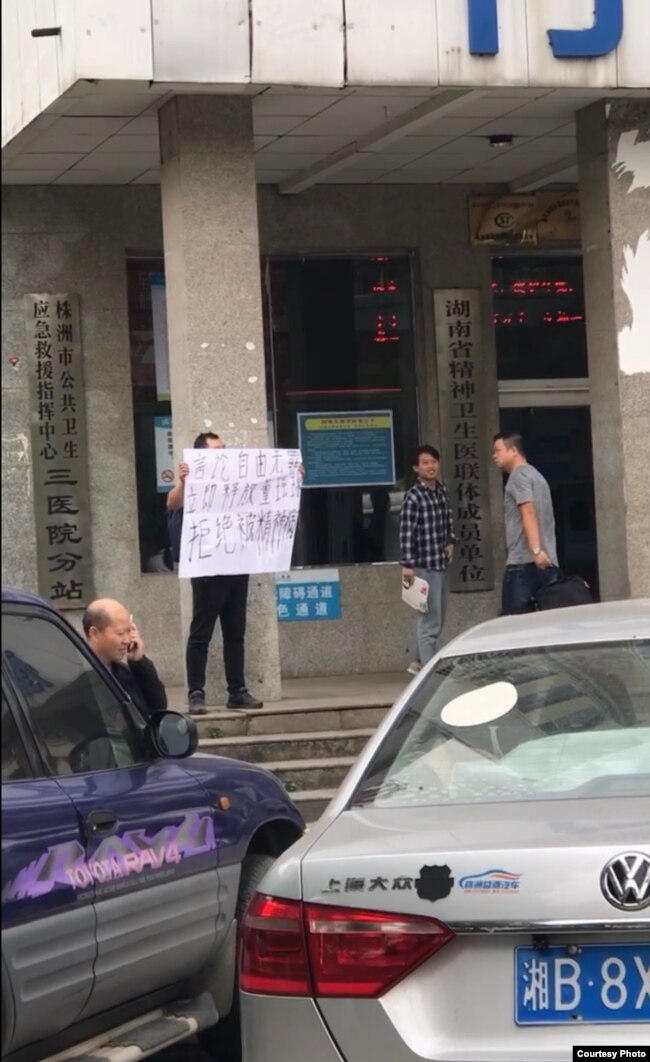 2019年10月22日,邱孝斌在湖南株洲三医院门前举牌声援“泼墨女孩”董瑶琼