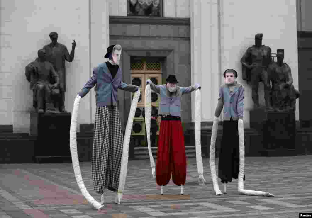 Activists wearing masks take part in a &quot;Performance Against Old Faces&quot;, in front of the parliament building in Kyiv, Ukraine.