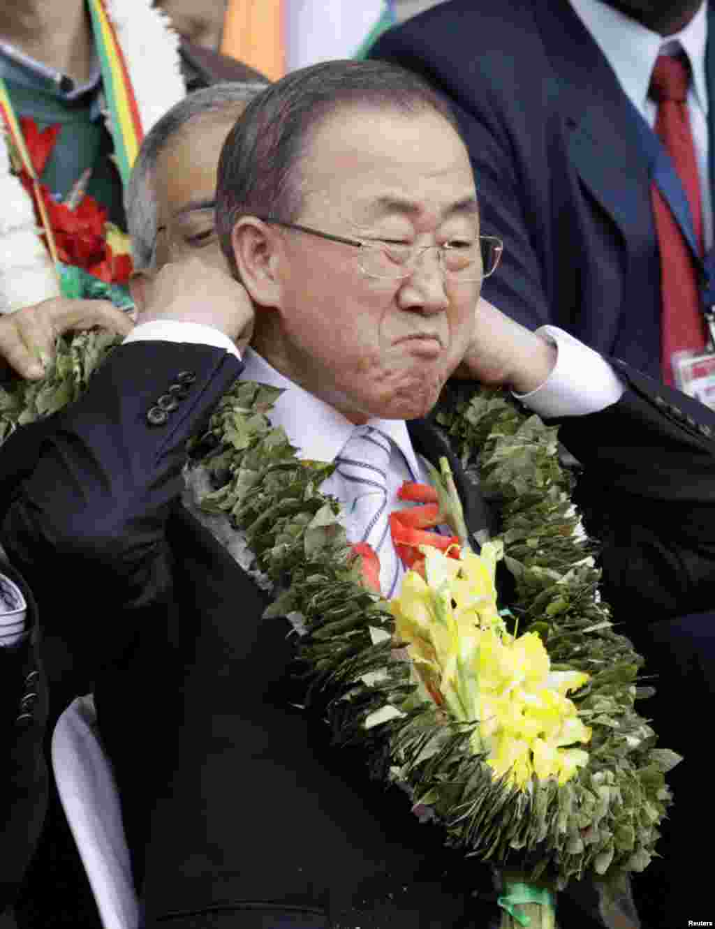 United Nations Secretary-General Ban Ki-moon adjusts his garland made with coca leaves during a welcome ceremony for delegates of the G77+ China Summit at Tahuichi Aguilera Stadium in Santa Cruz de la Sierra, Bolivia, June 14, 2014.