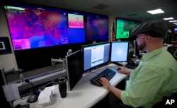 FILE - A specialist works at the National Cybersecurity and Communications Integration Center in Arlington, Virginia, Sept. 9, 2014.