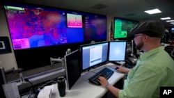 FILE - A specialist works at the National Cybersecurity and Communications Integration Center in Arlington, Virginia, Sept. 9, 2014.