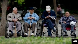 资料照 - 几位坐在轮椅上的年迈老人正在北京一座公园里休息。