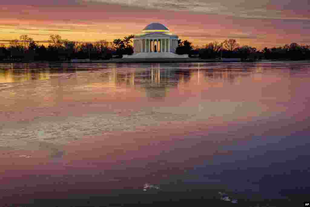 Sunrise reflects off of the frozen surface of the Tidal Basin in front of the Jefferson Memorial on a chilly start to the day in Washington.