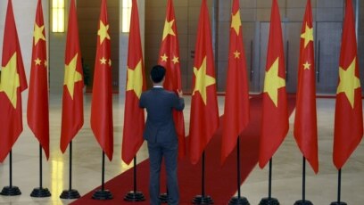 Một nhân viên chỉnh cờ Trung Quốc trước khi Chủ tịch Trung Quốc Tập Cận Bình tới Quốc hội Việt Nam tháng 11 năm 2015. (Ảnh minh họa).