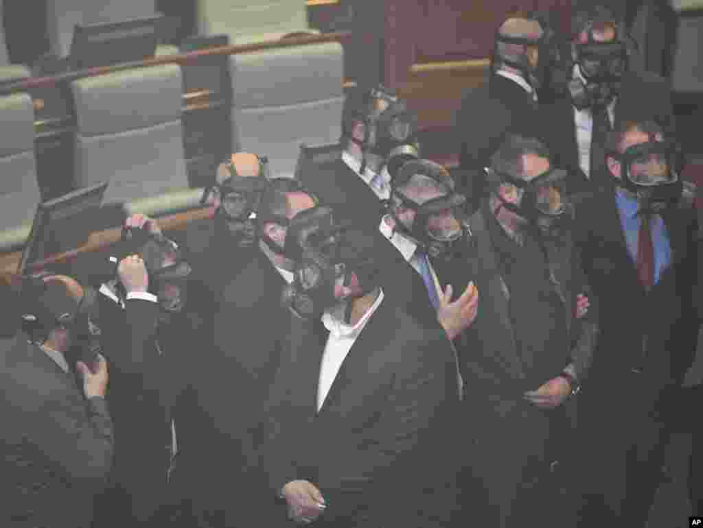 Kosovo parliament security wear gas masks after opposition lawmakers released a tear gas canister disrupting a parliamentary session in the capital Pristina.