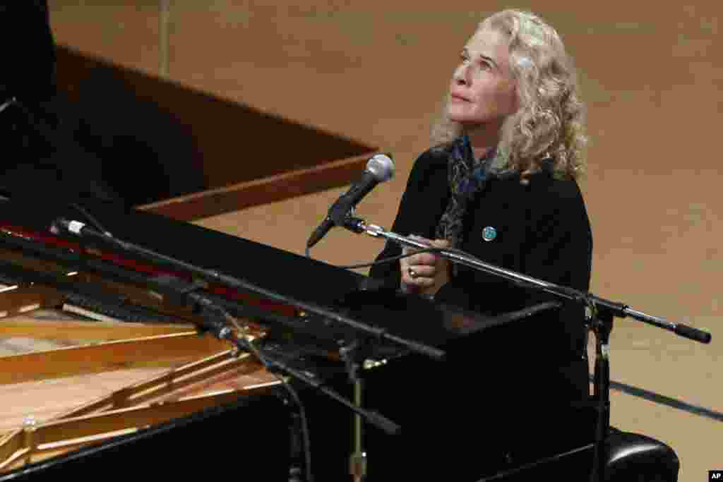 Singer Carole King puts her hands together after performing at a vigil for victims of the shooting at Sandy Hook Elementary School in Newtown, Conn. and other victims of gun violence, Dec. 12, 2013.