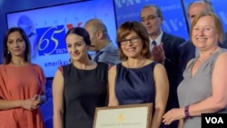 VOA Director Amanda Bennett (R) presents certificate of appreciation to members of the Armenian Service