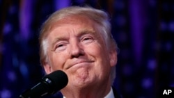 FILE - President-elect Donald Trump smiles as he arrives to speak at an election night rally. Despite Trump’s promises to reopen coal mines, pull out of the Paris climate treaty and roll back environmental regulations, there's only so much the president-elect can do once he begins governing next year.