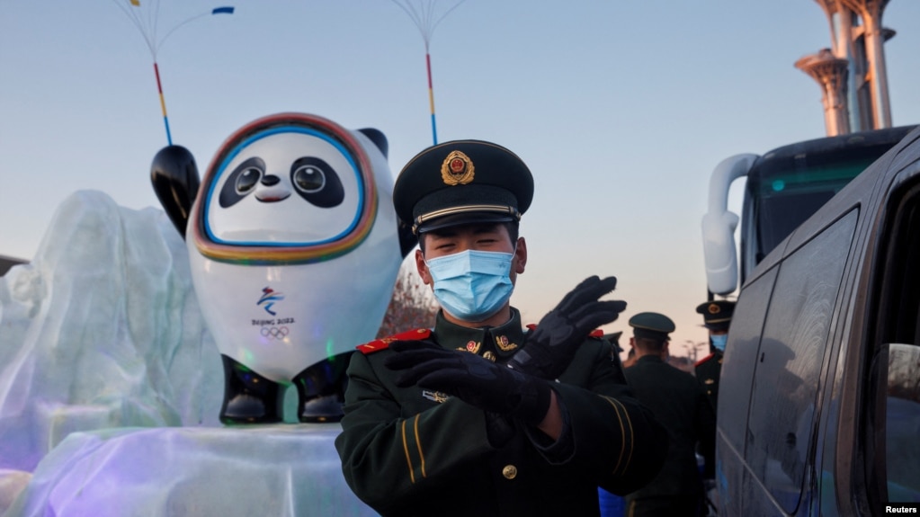 一名中国武警士兵在北京的冬奥会吉祥物前给拍照者做手势。（2022年1月15日）(photo:VOA)