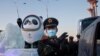 一名中国武警在北京的冬奥会吉祥物前给拍照者做手势。（2022年1月15日）